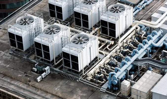 industrial HVAC cooling units and ventilation fans on a high-rise building rooftop